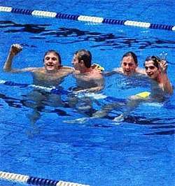 Four men in a pool celebrating