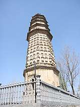 A wide, octagonal pagoda. It has four tall, functional floors made of brick, and an additional five, short, purely decorative floors made of wood. Each floor is separated by an eave, and the top five floor's eaves look as if they were simply stacked right on top of one another.