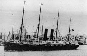 Black and white photograph of the ship in an unidentified harbour.