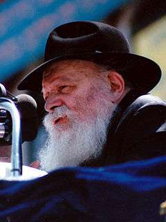 Chest high portrait of Rabbi Menachem Mendel Schneerson wearing a black hat