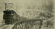 A train hauled by two of the Z-1 locomotives, crosses a wooden trestle bridge