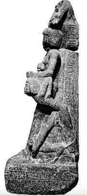 Standing man holding the hair of a man on his knees.