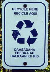A rectangular sign with rounded corners, text about recycling, and the recycling symbol