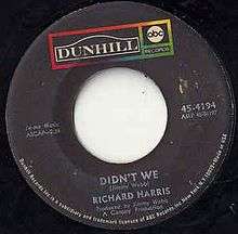 A black vinyl record of the single appears