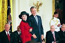 Photograph of President George W. Bush stands with Rita Moreno
