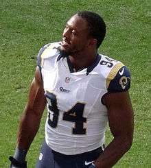 An American football player smiling without a helmet on.