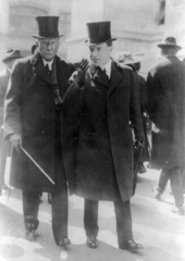 An image of John D. Rockefeller and John D. Rockefeller, Jr. walking down a street.