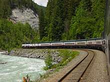 Train rounding a curve next to a river