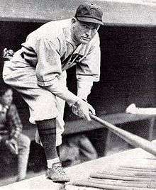 Rogers Hornsby kneeling on the dugout steps.