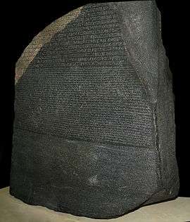 A large stone slab of dark rock covered in inscriptions.