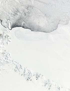 A wide expanse of ice covering the bottom two-thirds of the satellite image, and icy water covering the rest. There are dark mountains in the bottom-left.