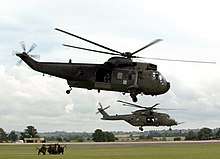 A Sea King HC4 (foreground) accompanied by a Merlin HC3 of the Commando Helicopter Force at RNAS Yeovilton.
