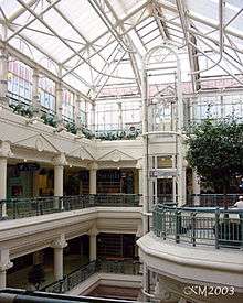 Interior of multi-storey shopping centre atrium with glass roof