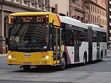 Photo of yellow and white articulated bus