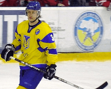 An ice hockey player in full gear skating on the ice