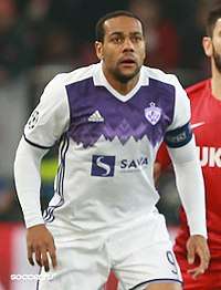 An Afro-Brazilian man in a white-purple football kit.