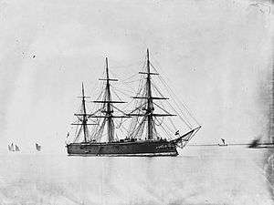 A large black warship with three tall masts