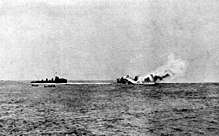 A large, burning warship rolling over and sinking; a smaller, black ship is nearby with two small boats.