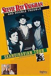 A yellow poster with a black-and-white image occupying most it. The image shows Stevie Ray Vaughan and Double Trouble staring at the viewer as Vaughan stands in the center with a slight smile on his face. Text on the poster reads "Stevie Ray Vaughan and Double Trouble Skandinavian Tour" and "Special festival appearance at Vossa Jazz Fri. 23. Albums Texas Flood CBS (Epic EPC 25534) New LP Couldn't Stand the Weather CBS (Epic EPC 25940)".