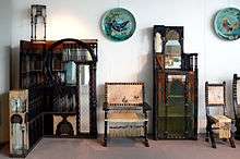 Two chairs and two cabinets made out of dark wood, with oriental forms