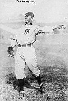A baseball card of a player in a white and black uniform