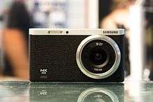 Black colored Samsung NX mini camera with lens
