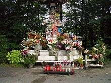 A statue, covered with flowers.