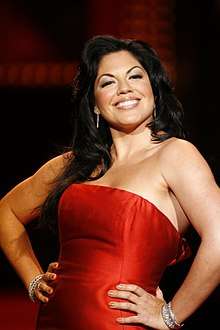 Sara Ramirez posing for the camera in a red dress