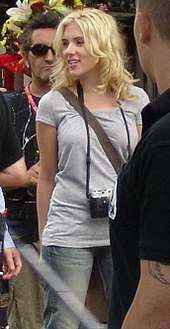 Scarlett Johansson with tousled medium length blonde hair loosely around her shoulders and face, looking to her right.