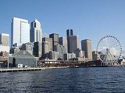 Vew of the downtown Seattle skyline, on the waterfront, with the Seattle Aquarium on the left and Seattle Great Wheel on the right.