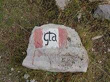 Rock with painted red-and-white flag and "GTA" in center