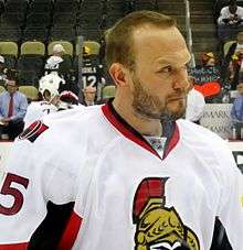 Sergei Gonchar shown from the chest up. He is wearing a white and red jersey.