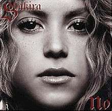 Black-and-white close-up image of a blonde woman looking directly to the camera. The words in red letters "Shakira" and "No" are displayed on the upper left corner and on the lower right corner of the picture, respectively.