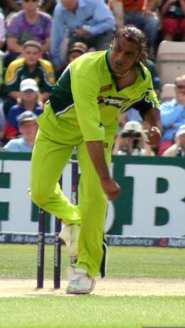 A man, in Pakistani national cricket team ODI uniform, just after delivering the ball.