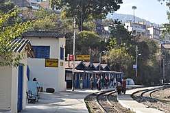 Station on a curve, with people waiting on the platform