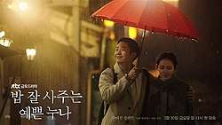 A man puts his arm around a woman as they walk in the rain sharing one red umbrella.