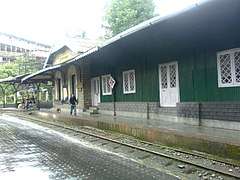 Station platform with a green building