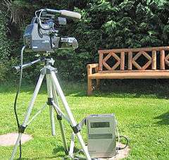 Large video camera outdoors on tripod