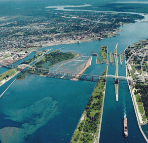 Aerial photography of a large locks system, a bridge, and two towns.