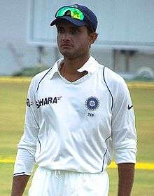 A man in the Indian test cricket uniform standing near the boundary line