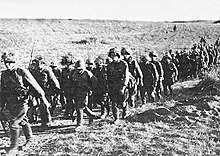 Soldiers marching through scrubland