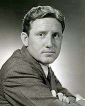 Black and white publicity photo of Spencer Tracy—a middle-aged white man with short curly hairstyle combed to the side and a square face, wearing a suit, in 1935.