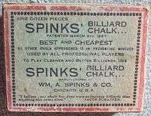 Image: A faded white cardboard box, about 3&nbsp;by&nbsp;4&nbsp;by&nbsp;1&nbsp;inches, with a red border and a lot of black text, reading "One dozen pieces SPINKS' BILLIARD CHALK" and various promotional slogans such as "BEST and CHEAPEST", and "USED BY ALL PROFESSIONAL PLAYERS", among other lines, some indistinct.