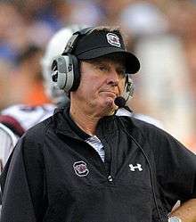 South Carolina head coach Steve Spurrier on the sideline wearing a visor and headset, with a disappointed expression