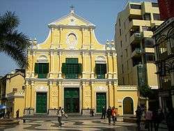The facade of a yellow baroque-style church