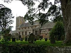 A stone church seen from the southeast with a clerestory and a battlemented west tower