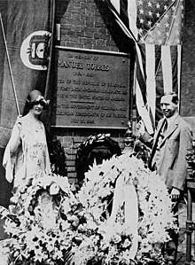 Olaya and his wife have drawn back the flags of Colombia and the United States to reveal a bronze plaque.