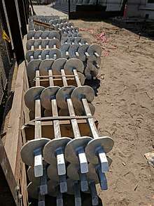 photo of a stack of helical anchors at a construction site