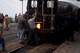 Two men behind a steam locomotive