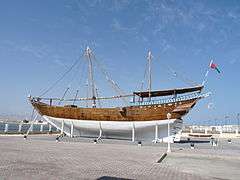 An Arabian dhow, a ship constructed with a covered area at the rear and no real superstructure. They are used as cargo vessels and have one or two masts with triangular sails.